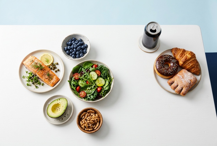 Fresh berries, leafy greens, avocado and nuts arranged on a light table